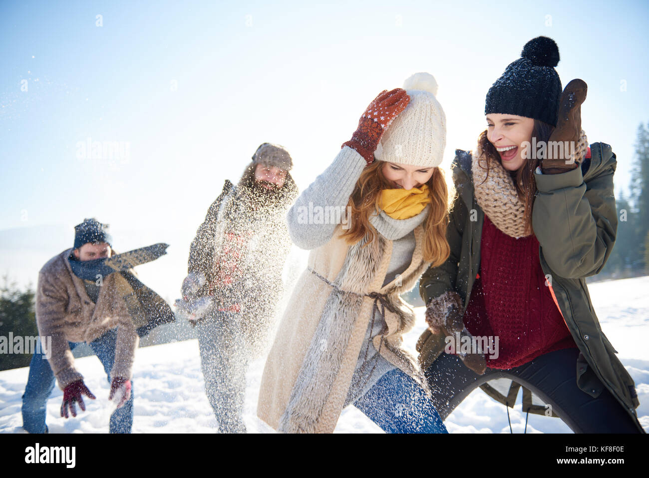 Boys against girls on the snowball fight Stock Photo