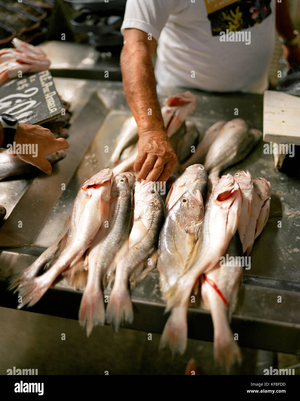 Brazil, Belem, South America, vendor picking up fish for customer at ...
