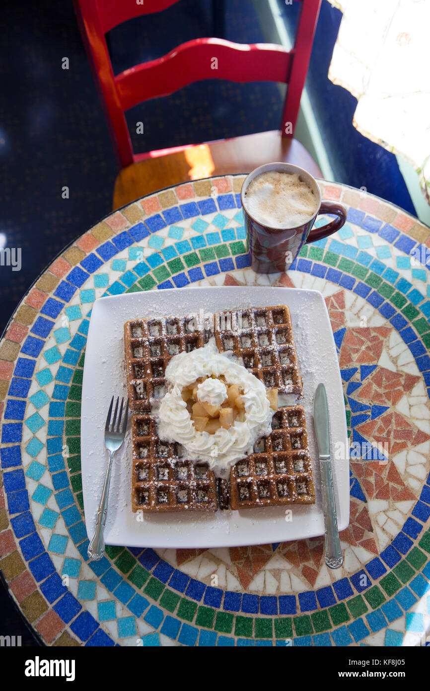 USA, Oregon, Ashland, interior table detail at the colorful Morning Glory Restaurant on Siskiyoui Blvd during breakfast, Gingerbread waffle with whipp Stock Photo