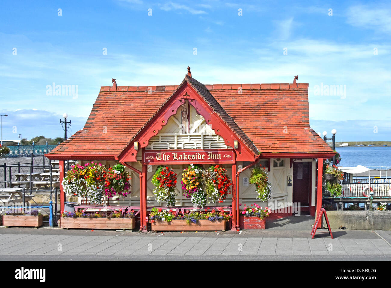 Summer flowers in planters & hanging baskets front of The Lakeside Inn on promenade beside Marine Lake in Southport one time smallest pub England UK Stock Photo