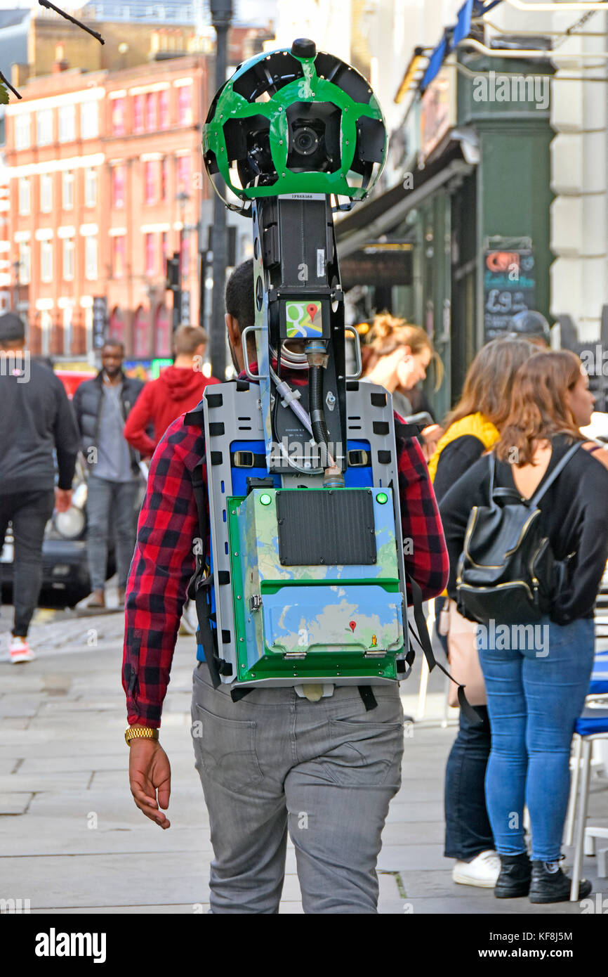 Google trekker camera back pack strapped to body man at work walks pavement used to make street view scenes on pegman maps London West End England UK Stock Photo