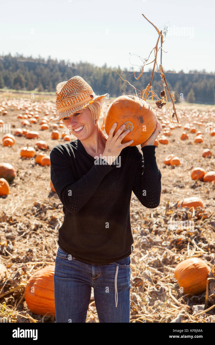 USA, Oregon, Bend, a woman chooses a pumpkin at the annual pumpkin ...