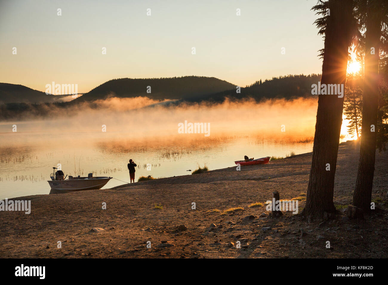 USA, Oregon, Paulina Lake, Brown Cannon, a young boy on the shoreline of Paulina Lake at dawn Stock Photo