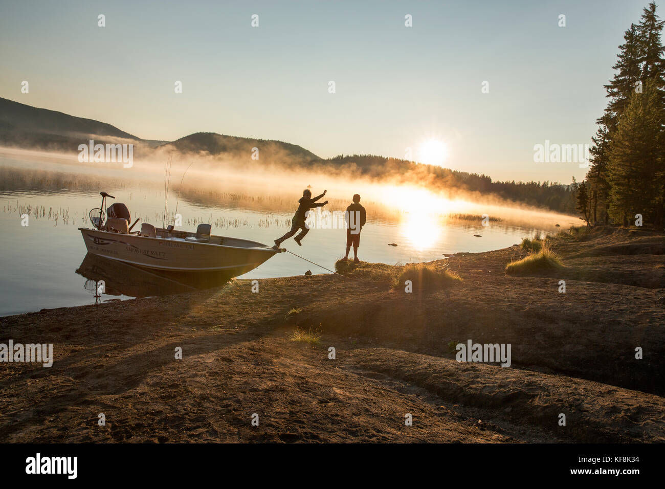 USA, Oregon, Paulina Lake, Brown Cannon, two young boys on the shoreline of Paulina Lake at dawn Stock Photo