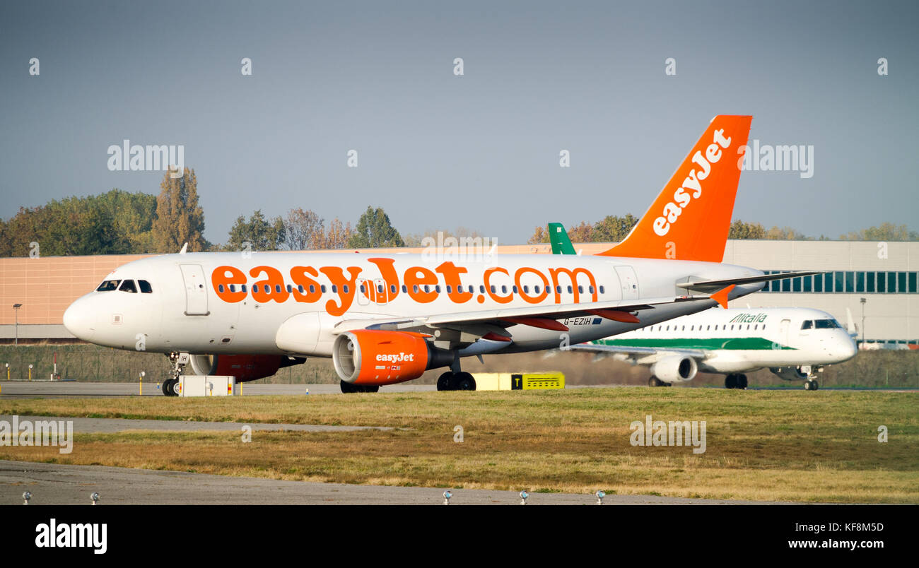 Milan Linate, Italy - Oct 25, 2017: An Easyjet Airbus A320-200 taxiing at Milan's Linate Airport, with an Alitalia airplane just behind Stock Photo