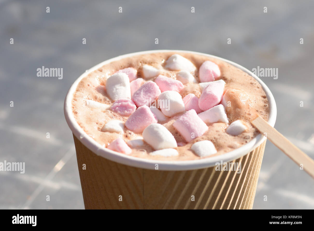 Takeaway hot chocolate drink with marshmellows and a wooden drinks stirrer Stock Photo