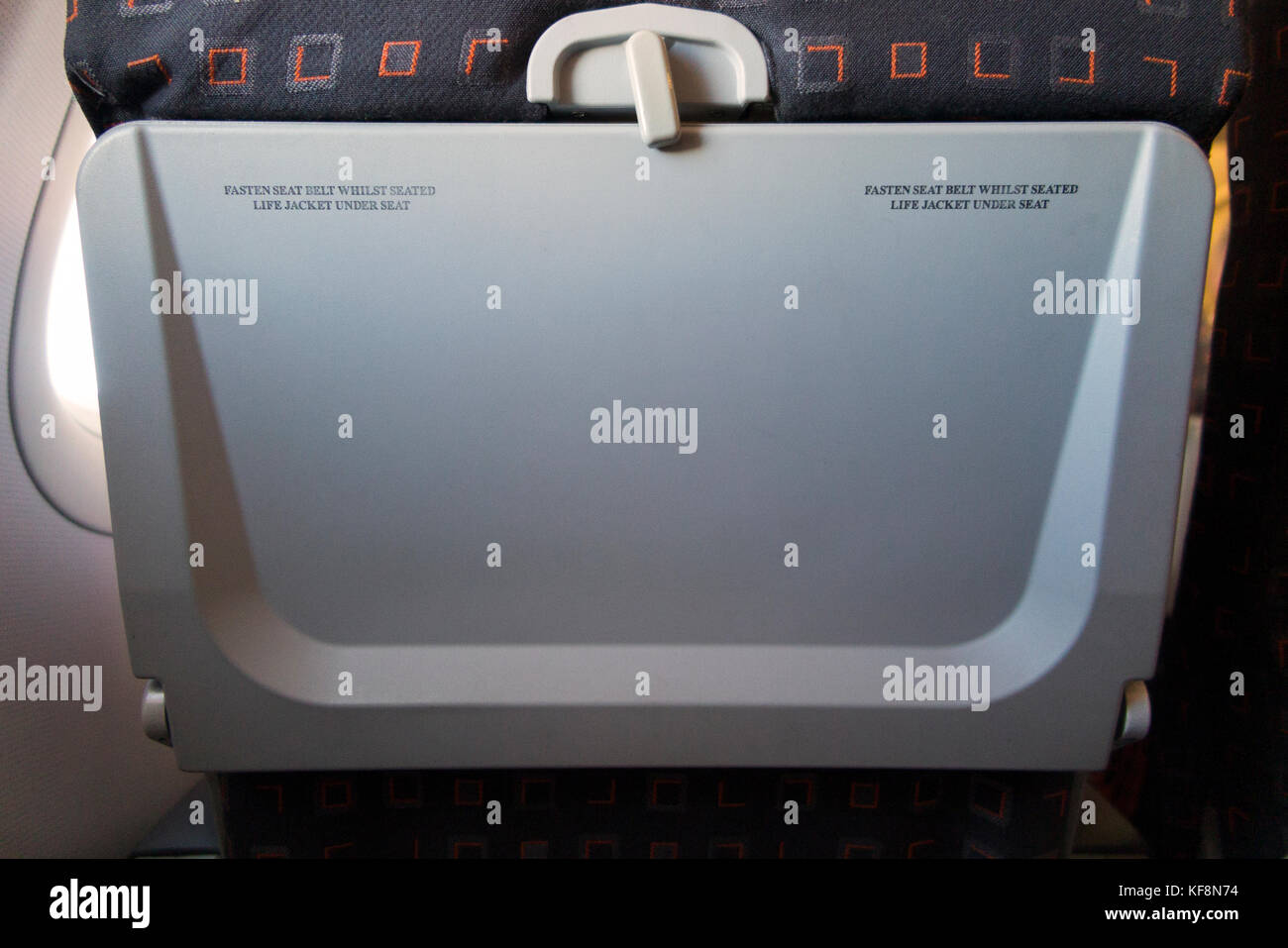 Passenger seat tray table in the full upright position on an Airbus A320-214 operated by Easyjet. (91) Stock Photo