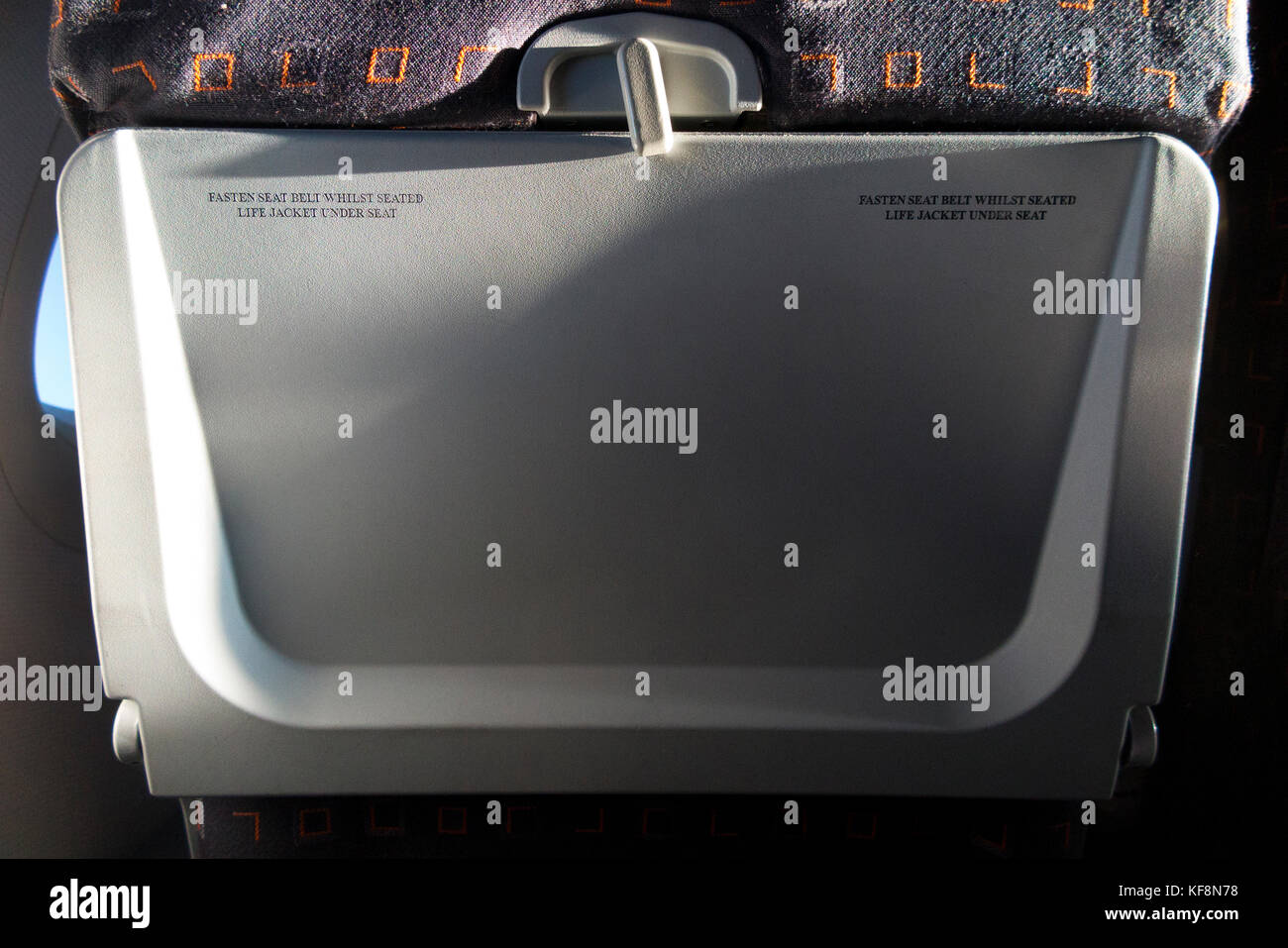 Passenger seat tray table in the full upright position on an Airbus A320-214 operated by Easyjet. (91) Stock Photo