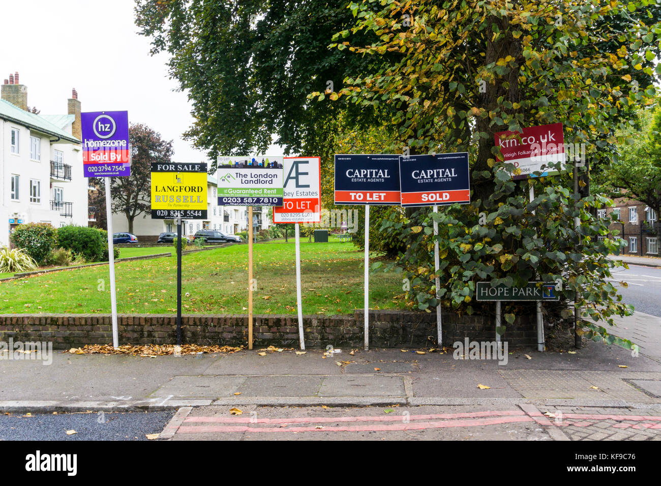 Multiple Sold, For Sale and To Let estate agents' boards outside a block of residential flats in south London. Stock Photo