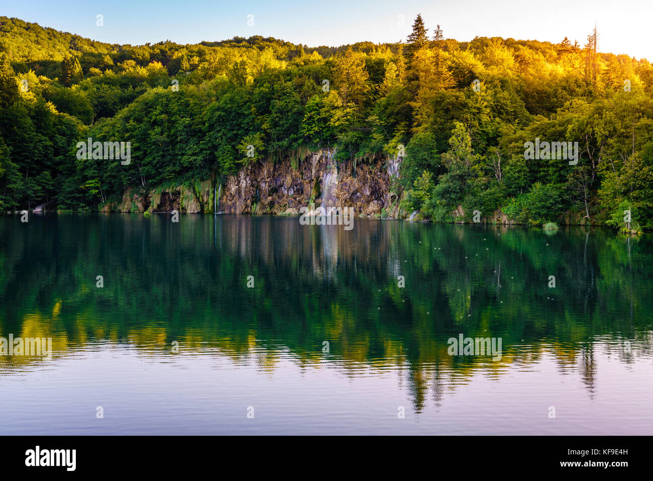 Waterfall reflecting in a lake in the evening at Plitvice Lakes National Park Stock Photo
