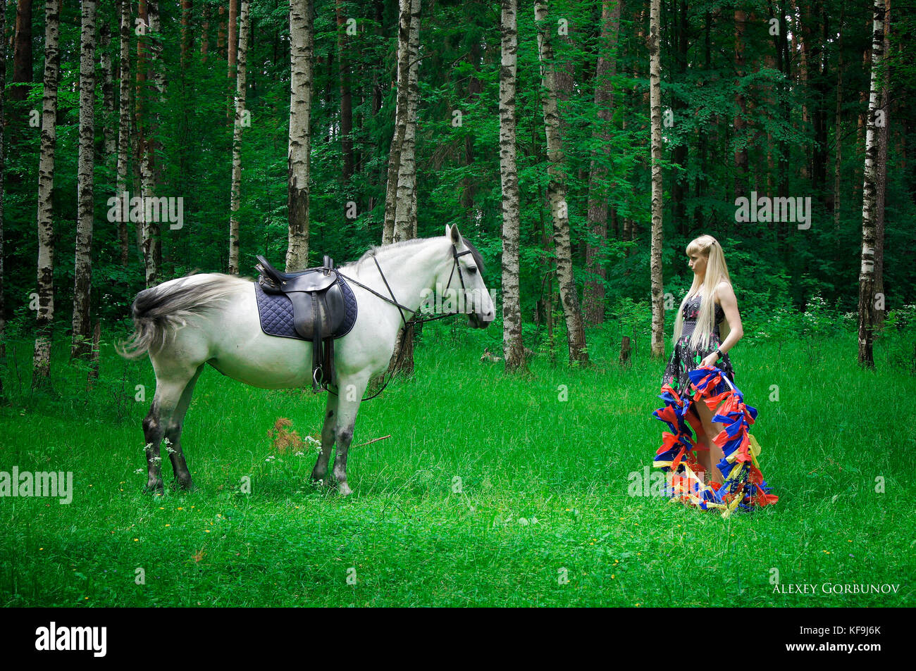 Girl and horse walking in the woods Stock Photo