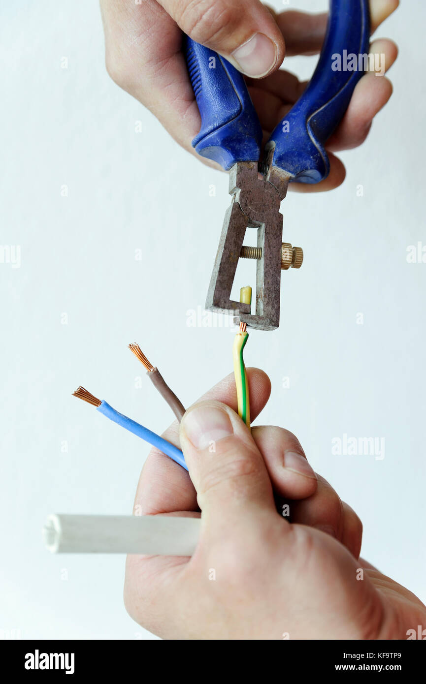 Wire stripping and removing insulation from the live wire of a 3-core cable  Stock Photo - Alamy