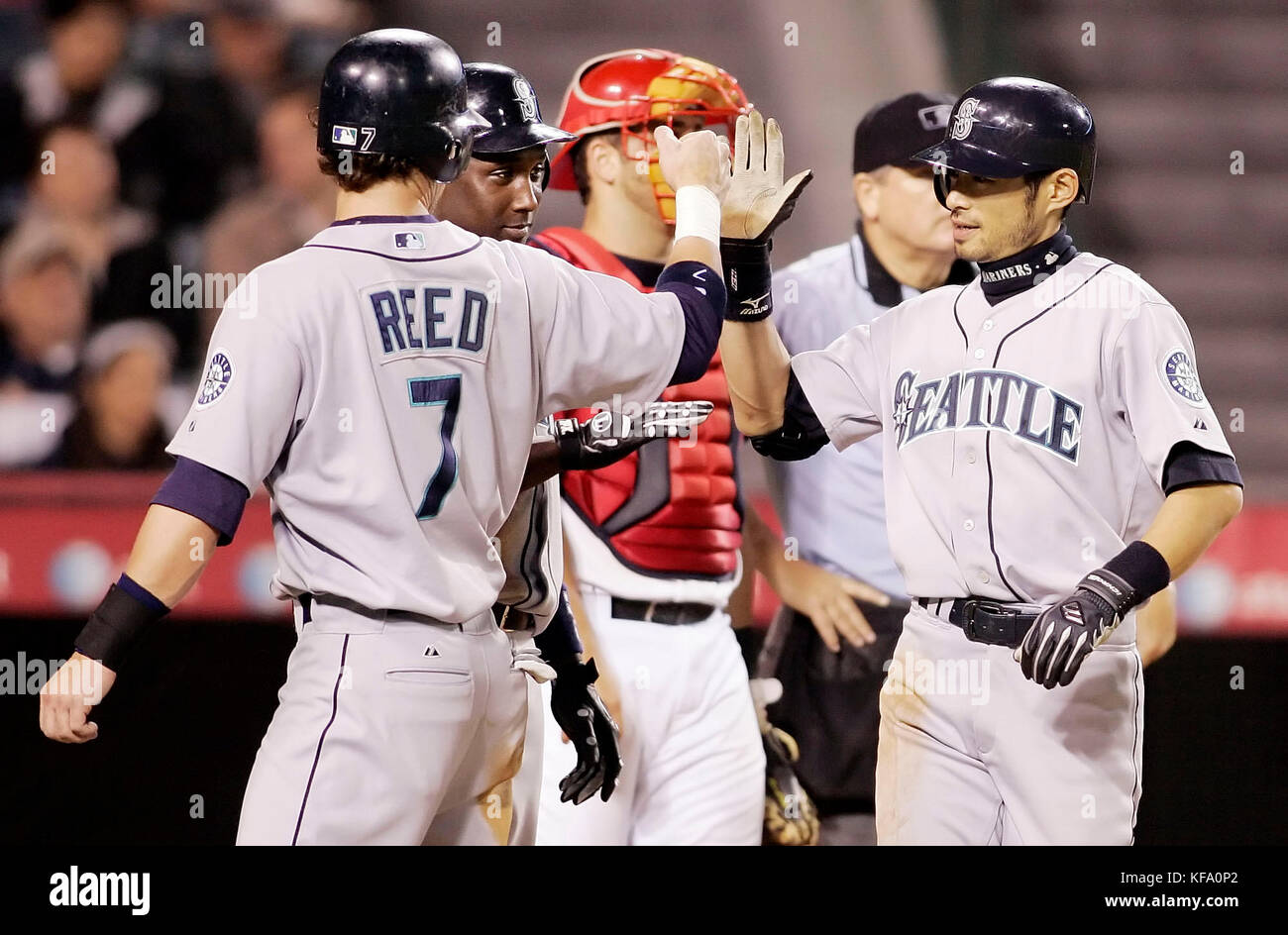 Seattle Mariners' Ichiro Suzuki, of Japan, right, is greeted at home by  teammates Jeremy Reed, left, and Yuniesky Betancourt, after hitting a  three-run homer off Los Angeles Angels pitcher Kevin Gregg in
