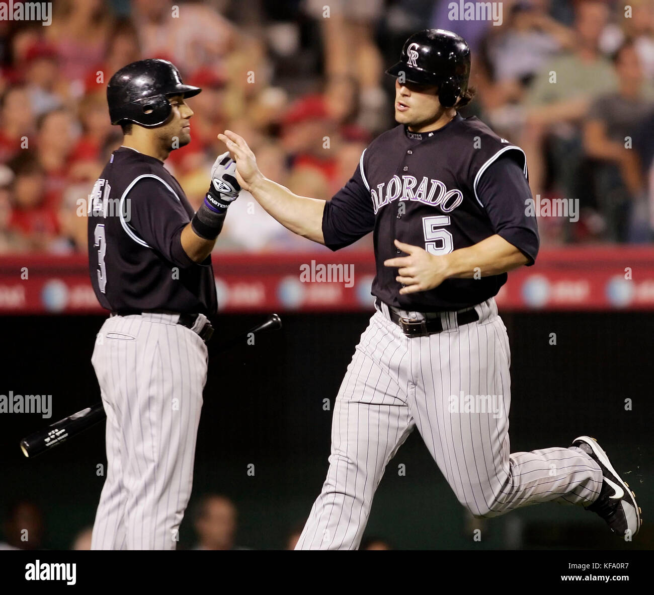 Colorado Rockies' Matt Holliday, right, gets a high-five from teammate  Jorge Piedra after scoring a run on a hit by Brad Hawpe off Los Angeles  Angels pitcher John Lackey in the sixth