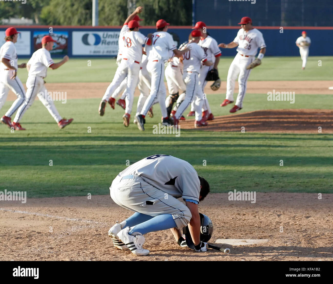 San Diego's Ryan Lilly, bottom, puts his head down at home plate while Fresno State players celebrate their 9-8 victory in an NCAA regional college baseball game in Fullerton, Calif. on Friday, June 2, 2006. Photo by Francis Specker Stock Photo