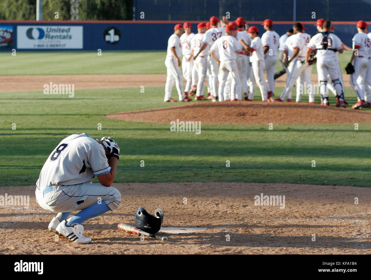 San Diego's Ryan Lilly, left, holds his head at home plate while Fresno State players celebrate their 9-8 victory in an NCAA regional college baseball game in Fullerton, Calif. on Friday, June 2, 2006. Photo by Francis Specker Stock Photo