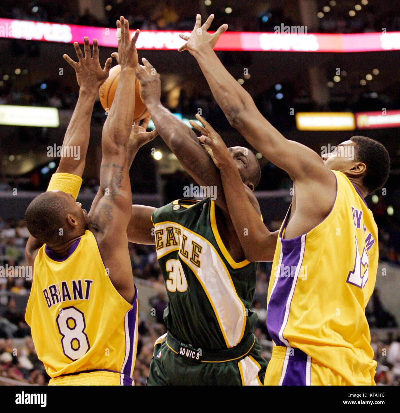 Los Angeles Lakers' Kobe Bryant, left, and teammate Lamar Bynum, right, stop the progress of Seattle Supersonics' Reggie Evans as he drove to the basket in the first half in Los Angeles on Thursday, Nov. 24, 2005. Bynum was called for a foul. Photo by Francis Specker Stock Photo