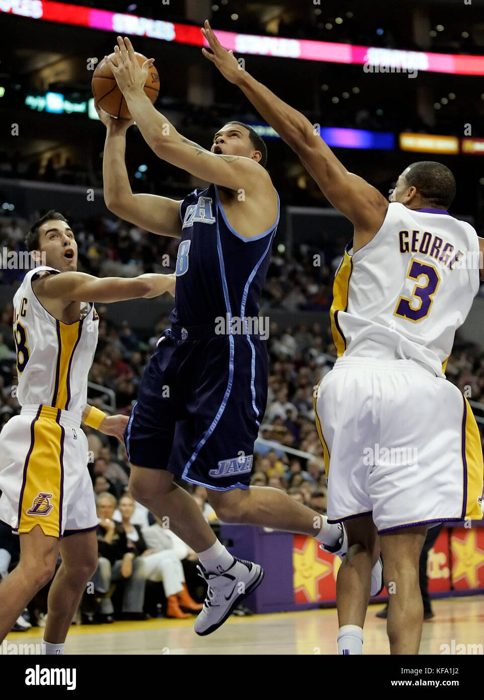 Utah Jazz's Deron Williams, center, shoots over the outstretched arms of Los Angeles Lakers' Devean George, right, and Sasha Vujacic of Slovenia, left,  in the first half in Los Angeles on Sunday, Jan. 1, 2006. Photo by Francis Specker Stock Photo