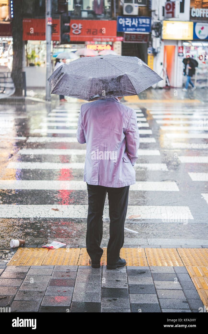 Korean people waiting at a crosswalk in the rain Stock Photo