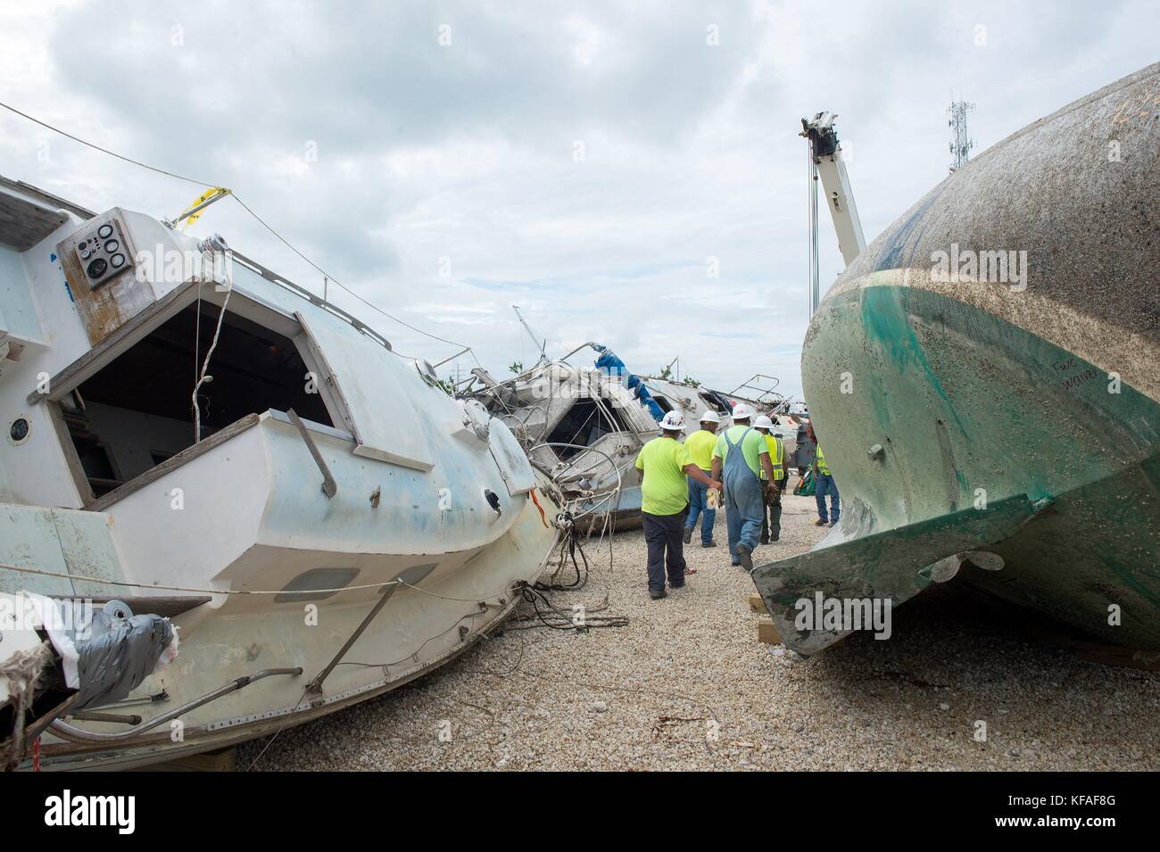 U.S. Coast Guard officers and response crews remove damaged boats from the Boot Key Harbor City