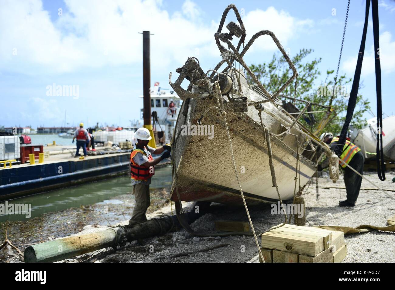 U.S. Coast Guard officers and response crews remove a damaged boat from the Boot Key Harbor City