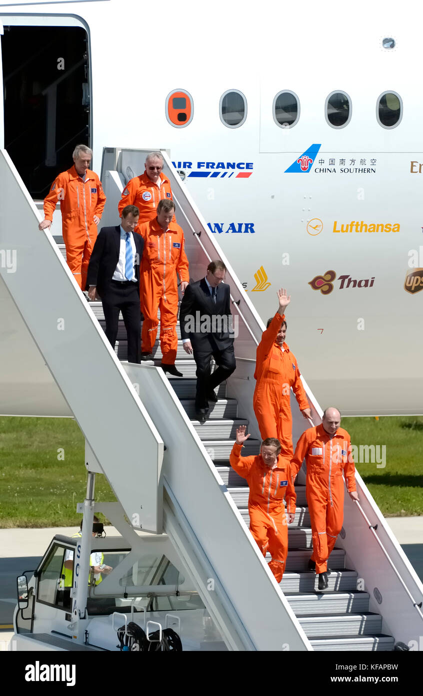 the first flight crew (all wearing orange flight suits) of the Airbus A380-841 with Noel Forgeard and Charles Champion walking down the airstairs. The Stock Photo