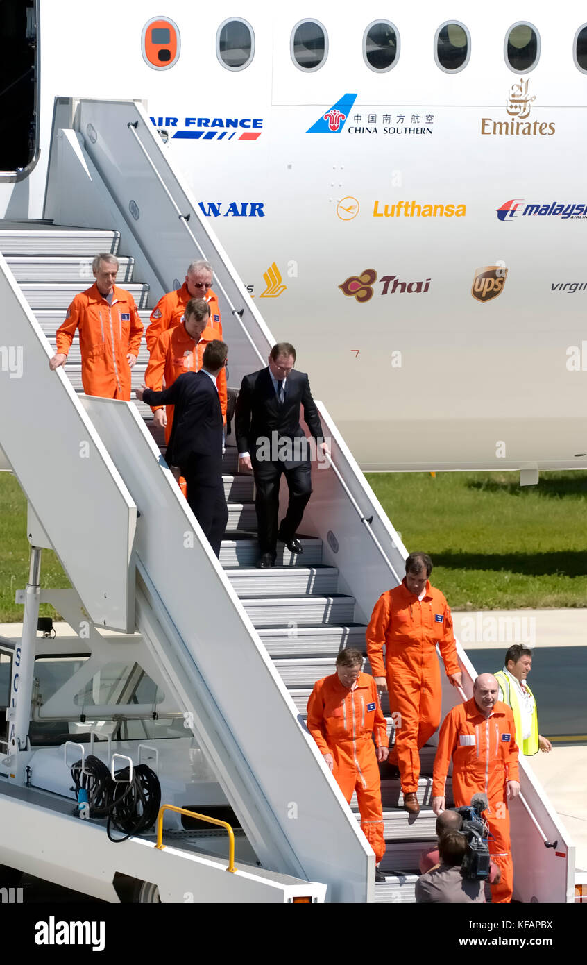 the first flight crew (wearing orange flight suits) of the Airbus A380-841 Claude Lelaie, Jacques Rosay and Fernando Alonso at the bottom of the airst Stock Photo