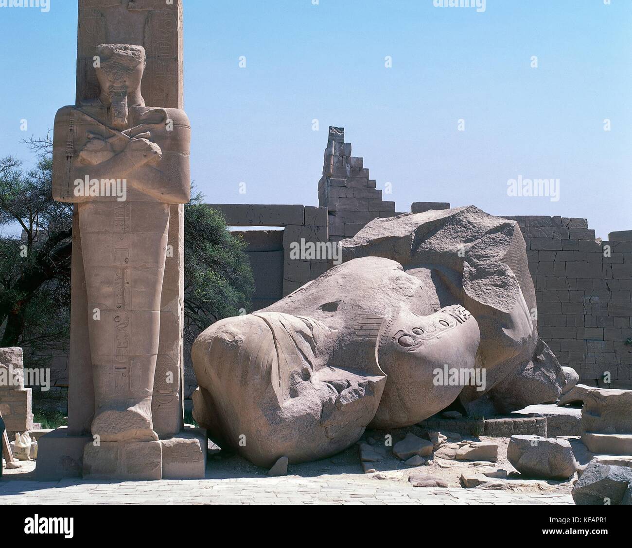Osirian pillar and the remains of the Colossus of Ramesses II, the first courtyard of the Ramesseum, mortuary temple of Ramesses II, Deir el-Bahri, Thebes (Unesco World Heritage List, 1979). Egyptian civilisation, Middle Kingdom, Dynasty XIX. Stock Photo