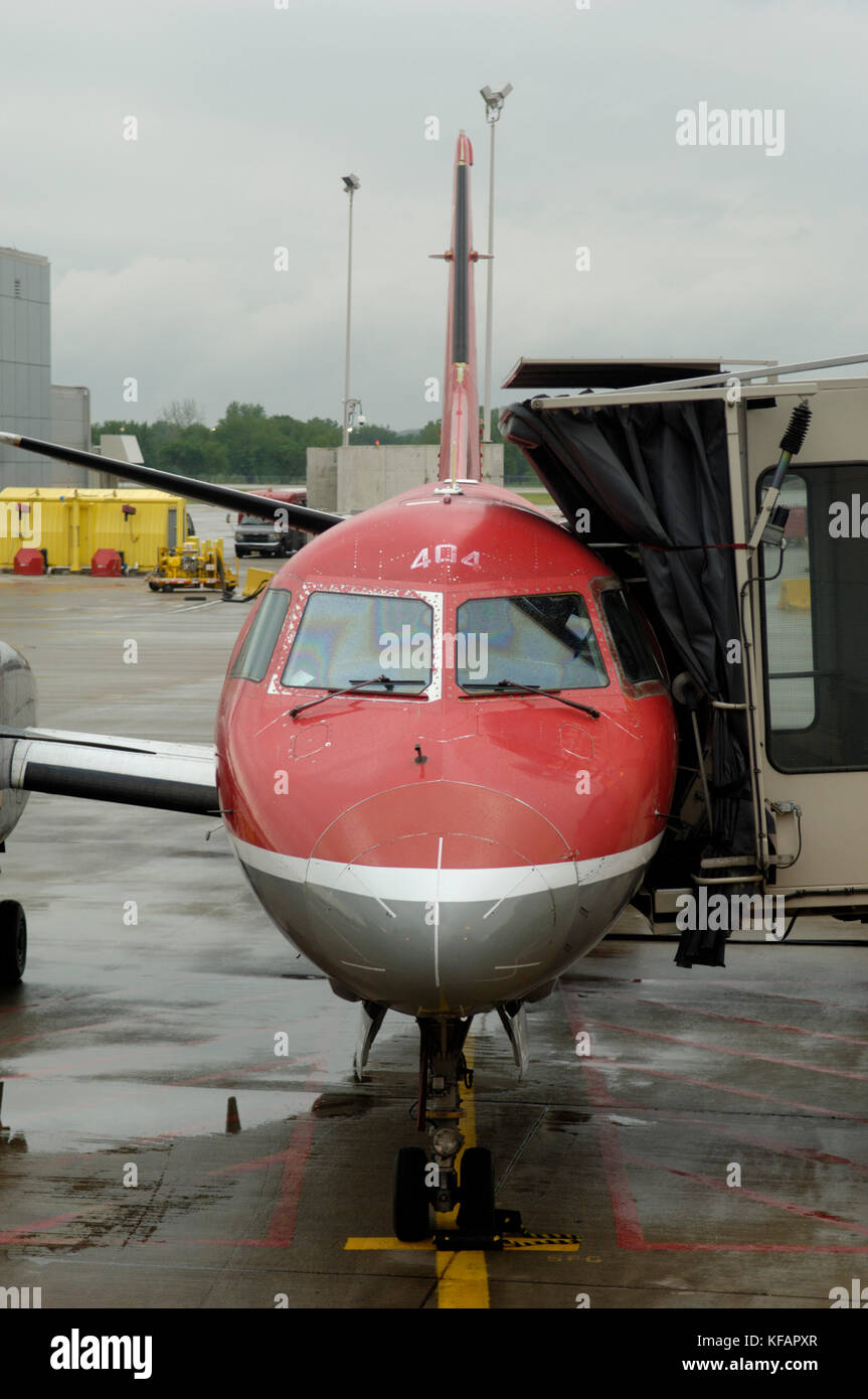 windshield and nosewheel undercarriage of a Northwest Airlink - Mesaba Airlines Saab SF-340B+ parked with jetway extended Stock Photo