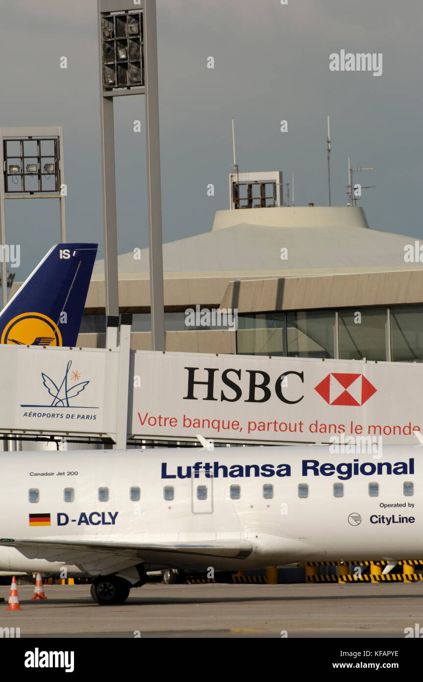 the Lufthansa CityLine, Germany Bombardier CRJ-100LR parked at the terminal with refuelling bowser and jetway with HSBC advert Stock Photo