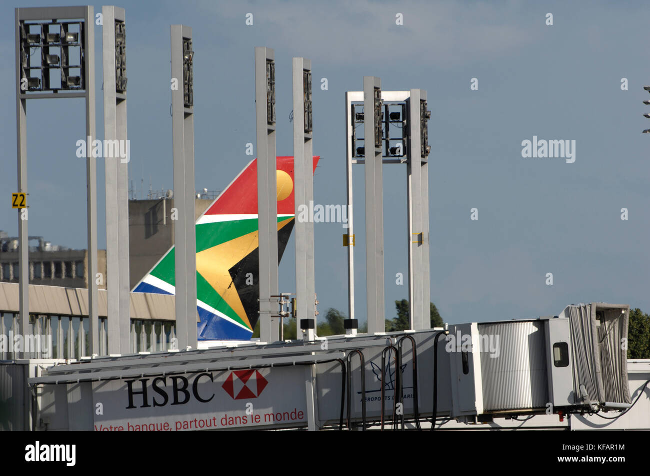 a South African Airways tail and a jetway with HSBC advert Stock Photo