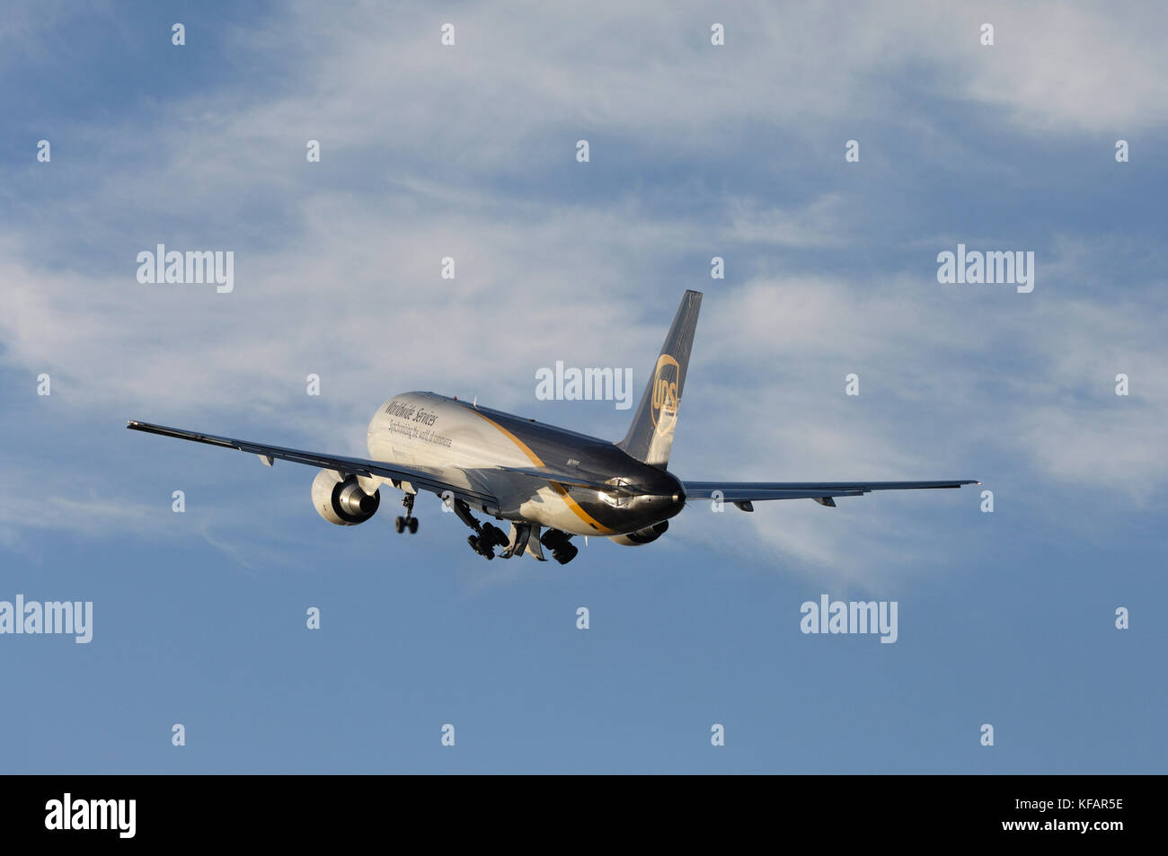a UPS United Parcel Service Boeing 757-200 climbing out after take-off with undercarriage retracting Stock Photo