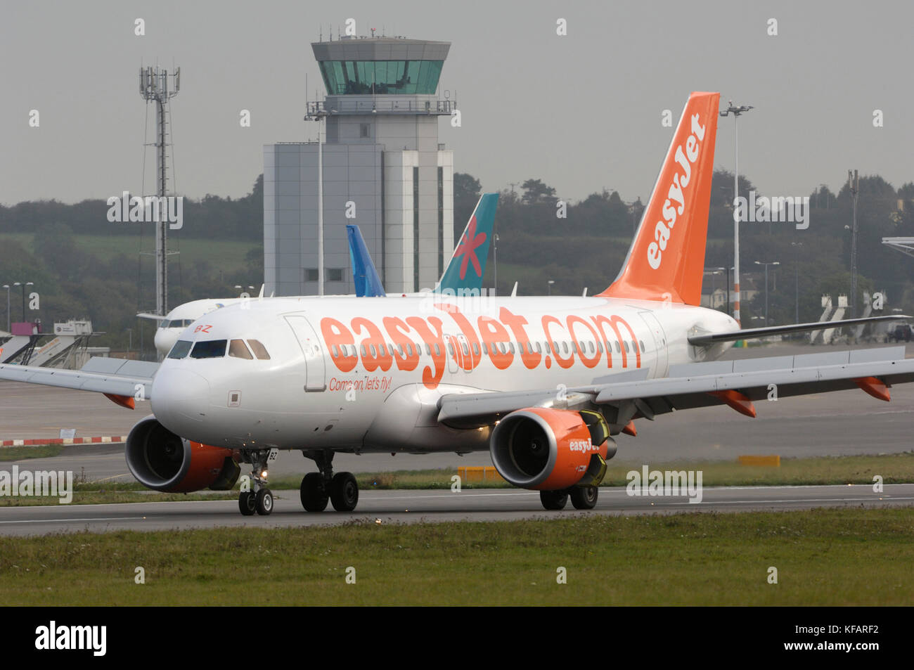 an easyJet Airbus A319-100 taxiing, the tails of a First Choice Airways Boeing 757-200 with an XL Airways 737-800 parked and the air traffic control-t Stock Photo