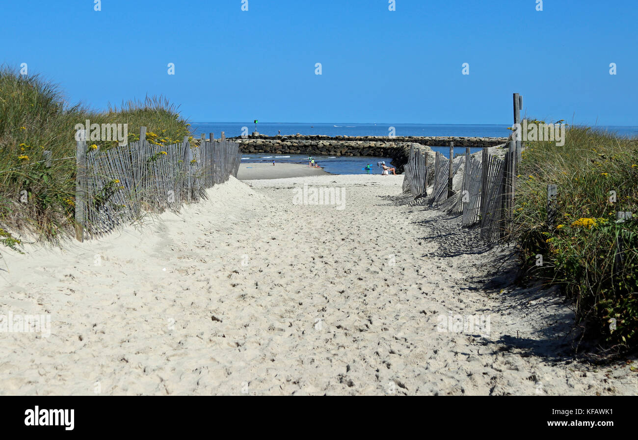 Sandy path to Harbor View Beach, marked by dunes and a wooden fence, with views of the Sesuit Harbor Jetty, Cape Cod, East Dennis, Massachusetts Stock Photo