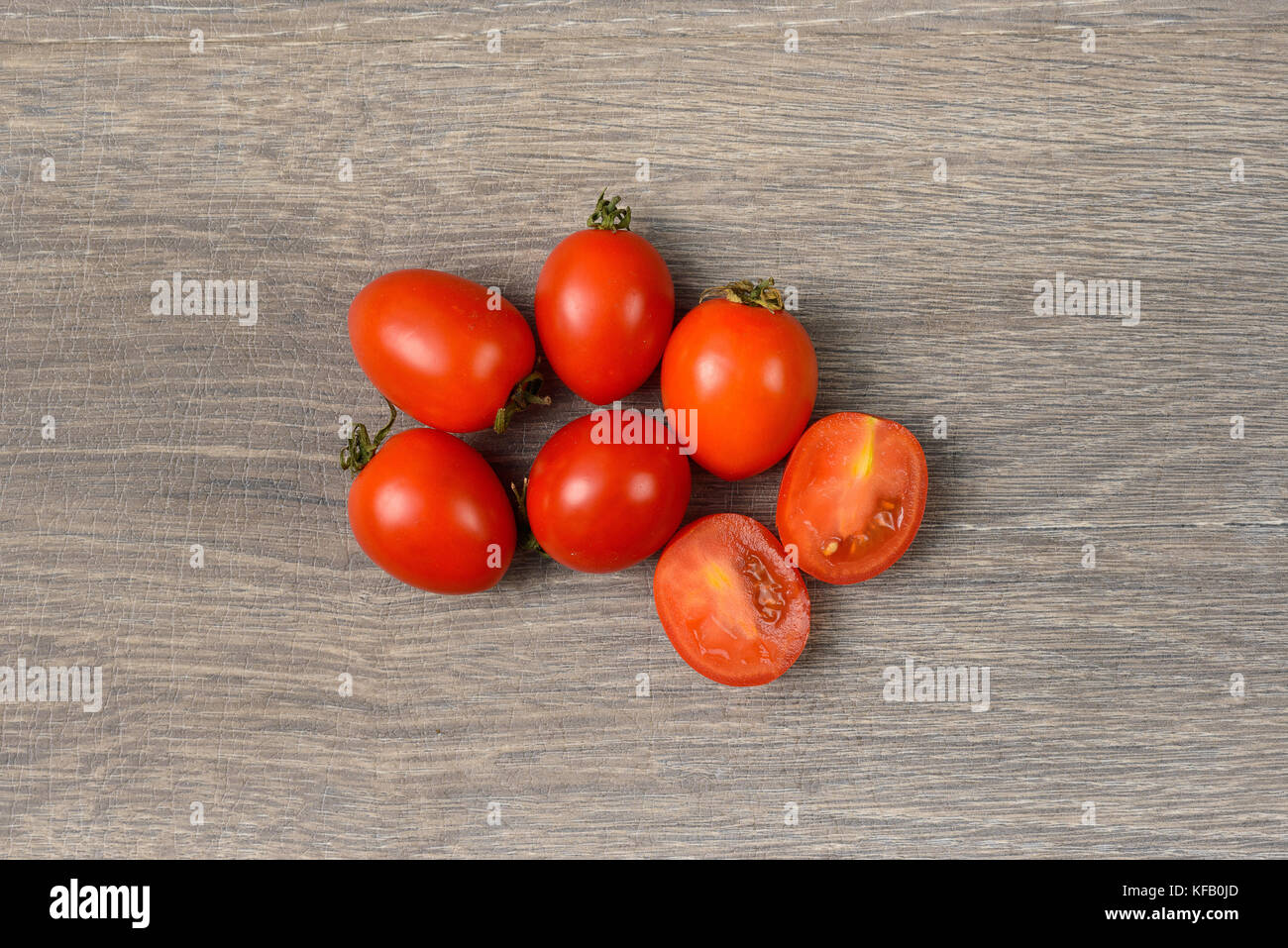 Tomatoes scattered on wooden table Stock Photo