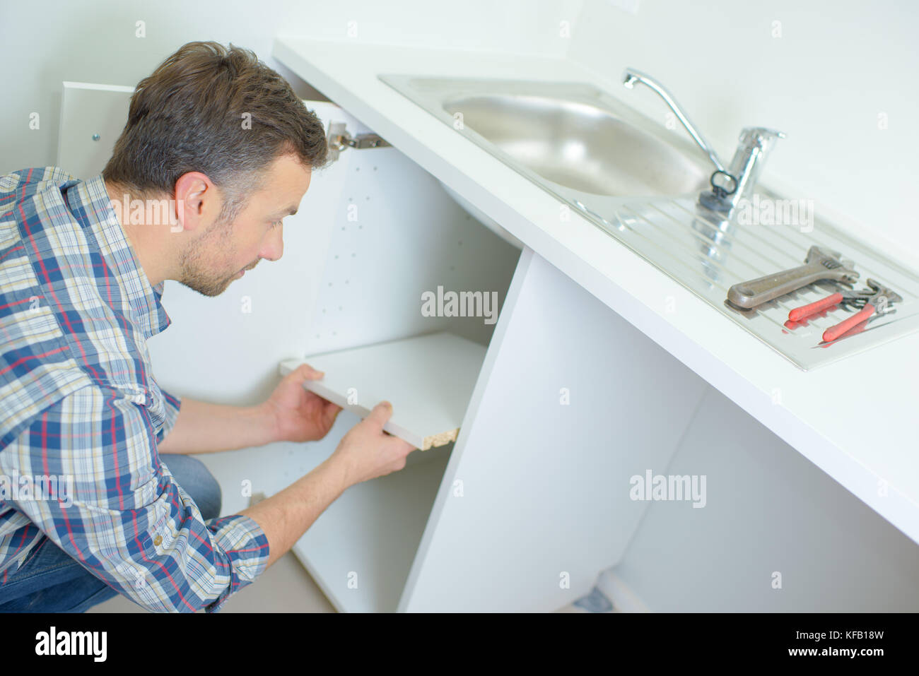 plumber removing the shelf under the sink Stock Photo Alamy