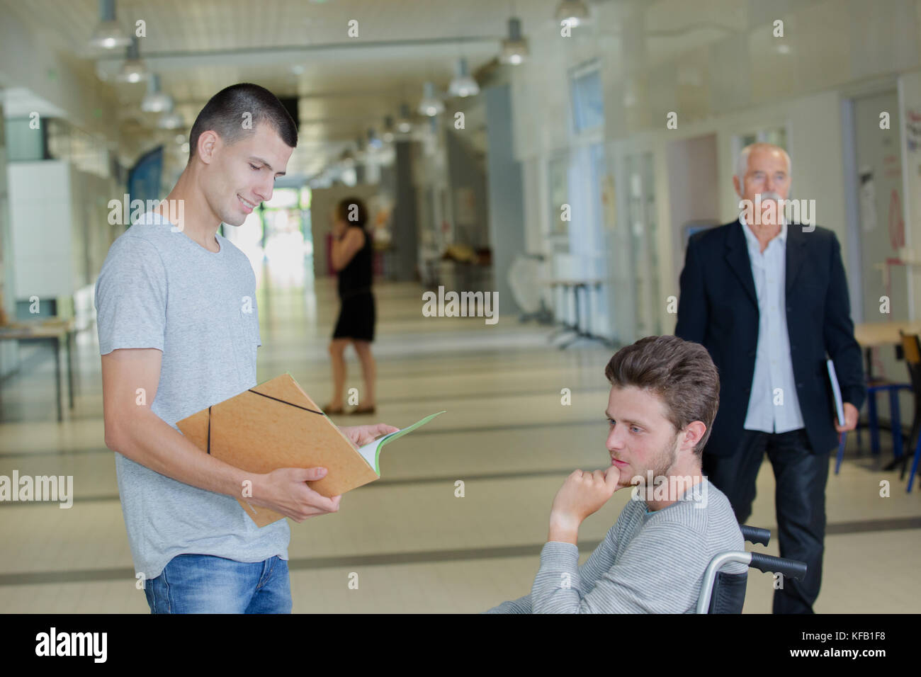 Students in foyer, one in wheelchair Stock Photo - Alamy