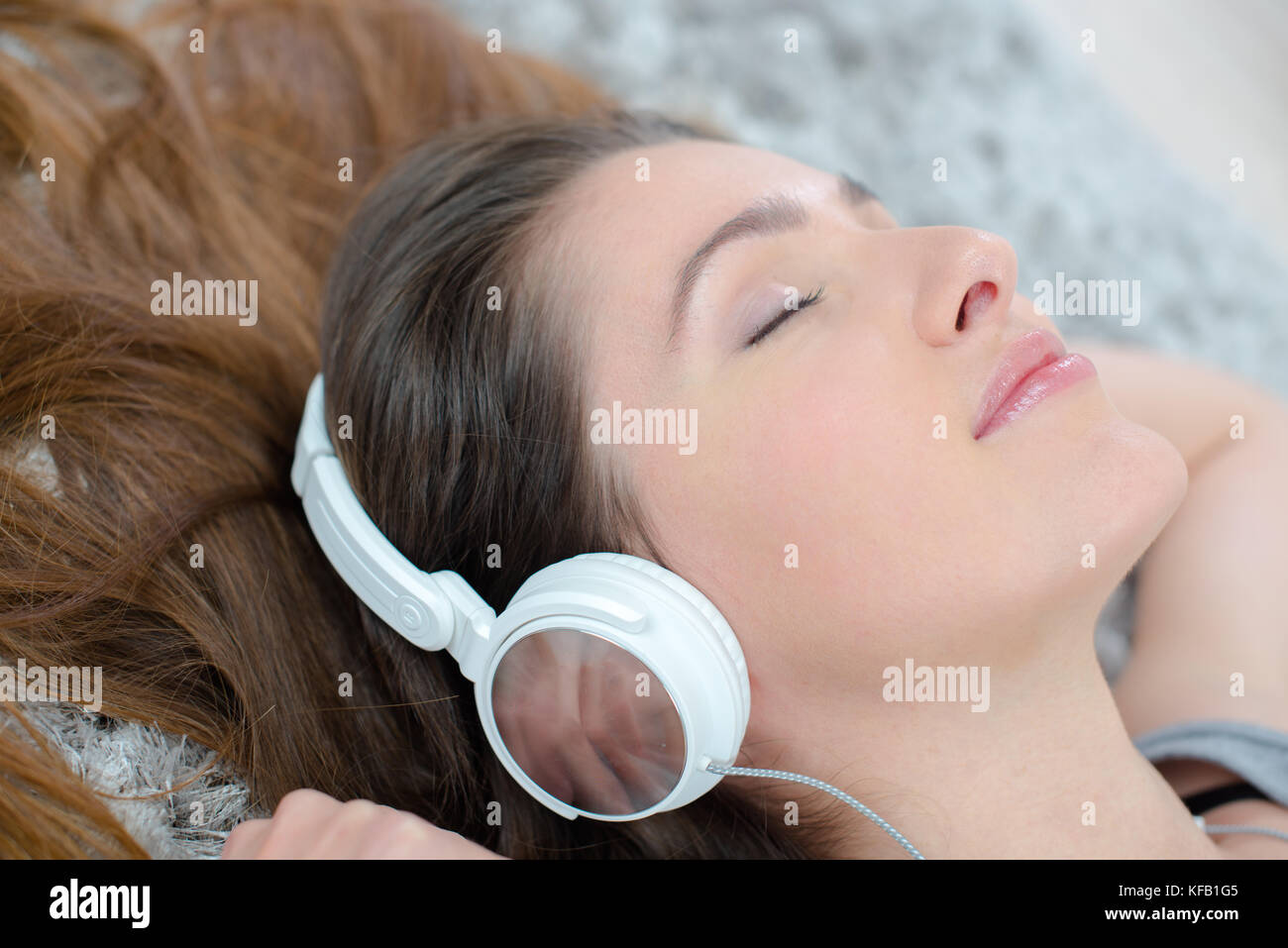 young woman lying on floor and listening to music Stock Photo - Alamy