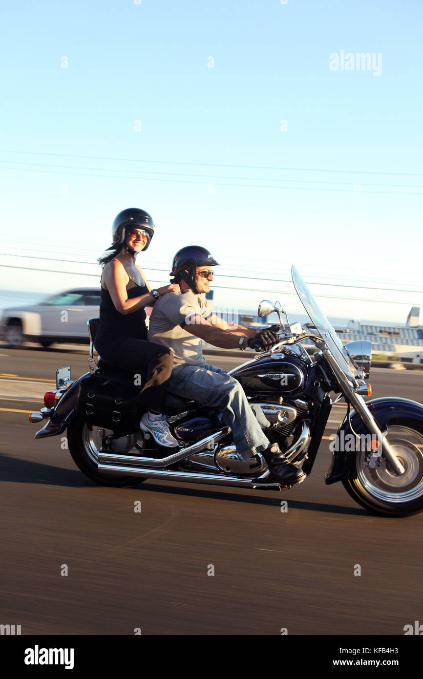 USA, California, Malibu, a couple on a motorcycle cruises along the Pacific Coast Highway at the