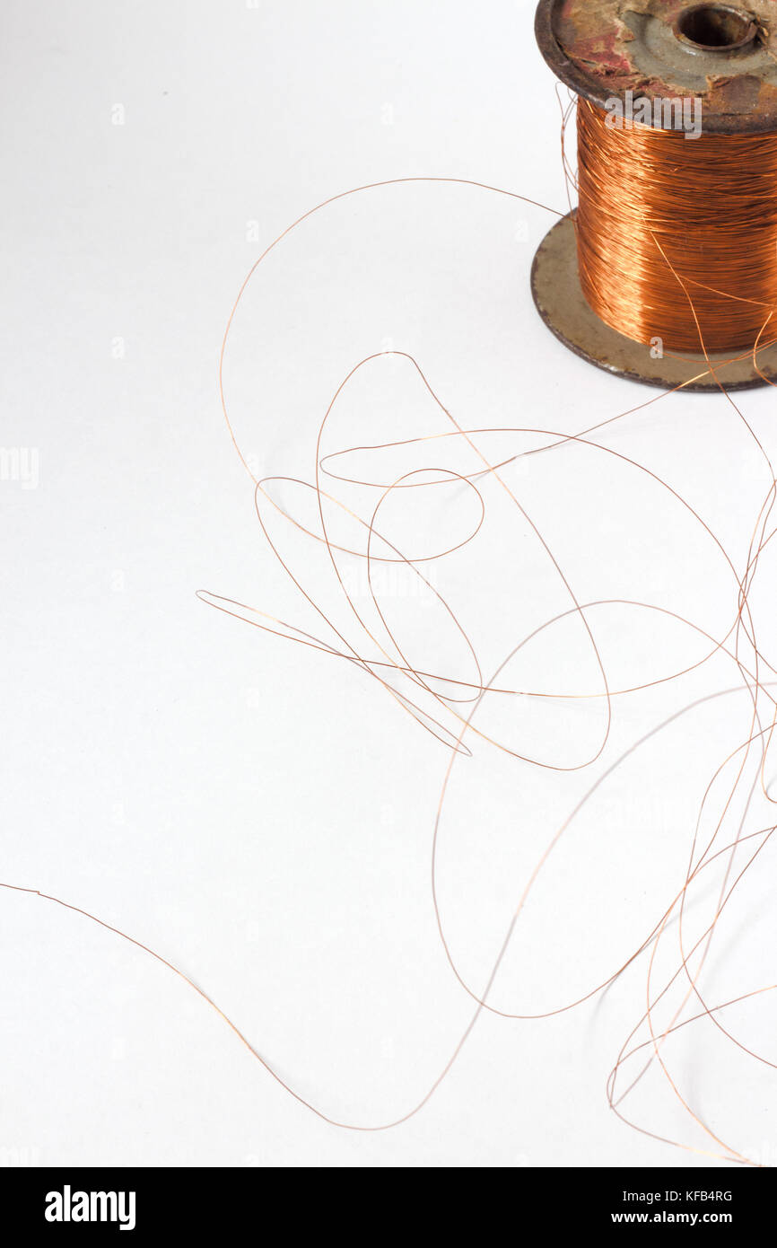 Copper wire spool. Red insulated wire wound up on plastic spindle. End