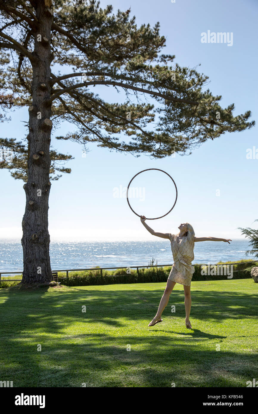 USA, California, Big Sur, Esalen, hula hooping on the lawn by the Lodge in front of the Pacific Ocean, the Esalen Institute Stock Photo