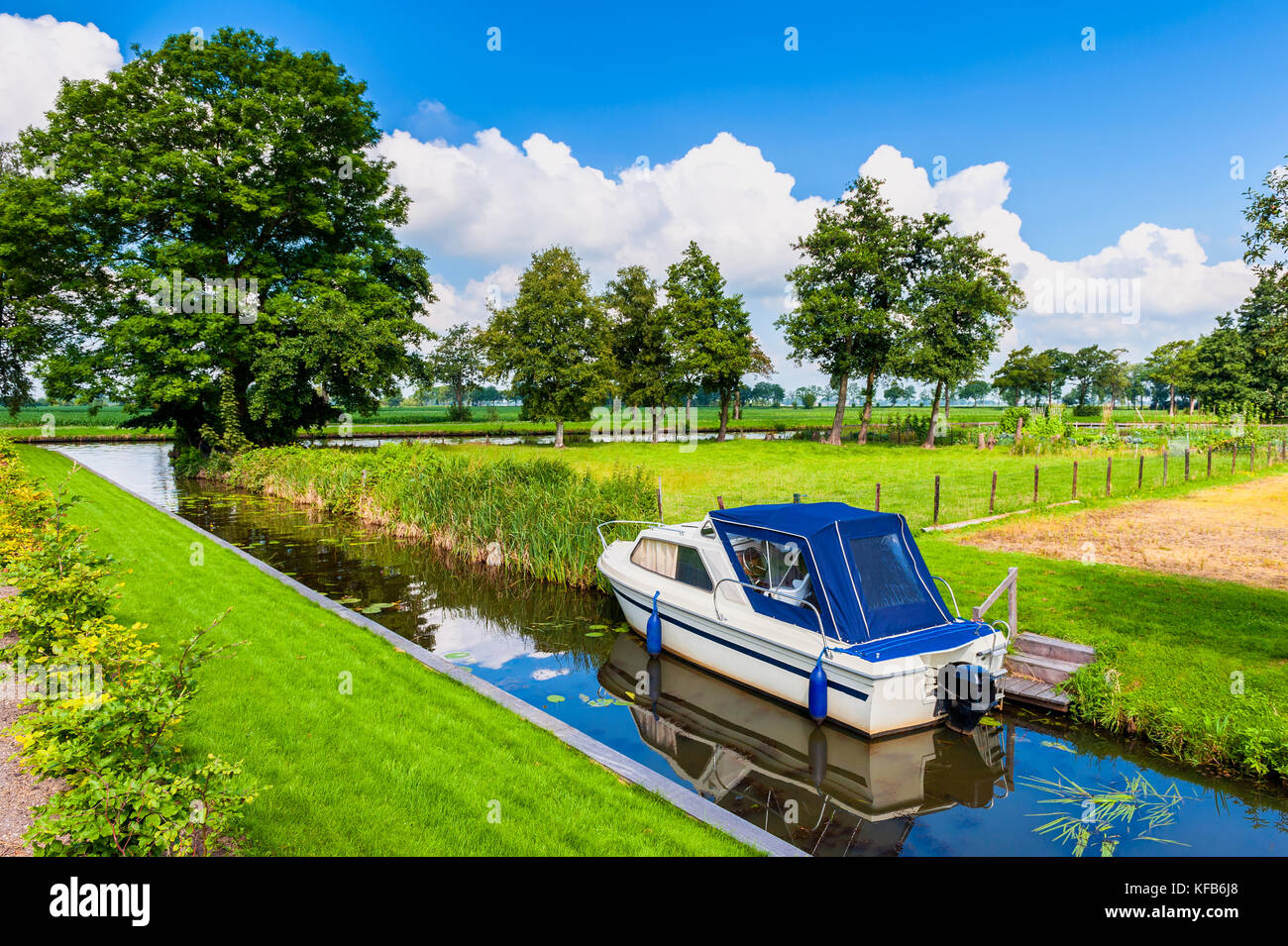 Small Canal with Motorboat in Giethoorn Netherlands on summer day Stock Photo