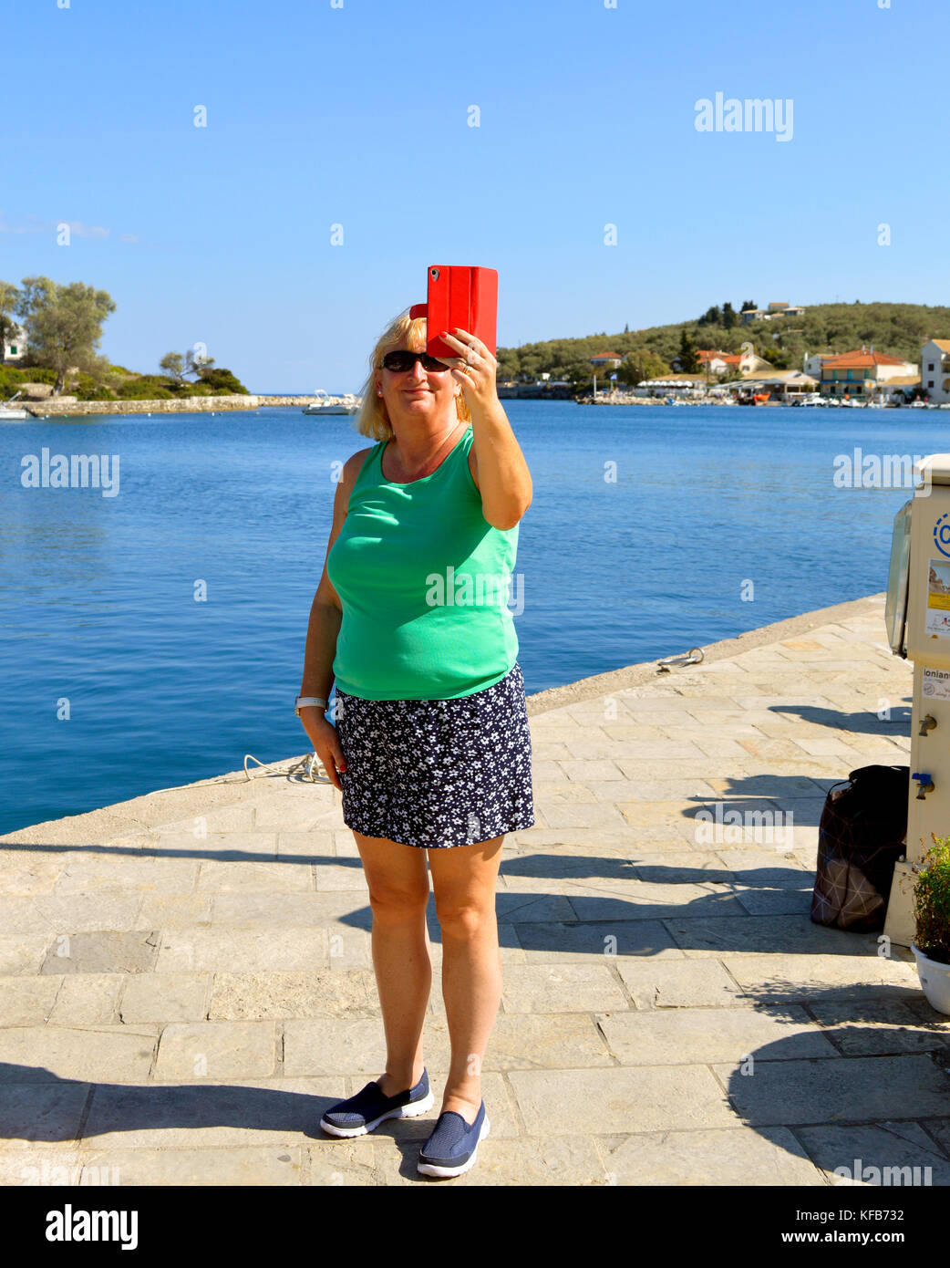 Lady taking a selfie in Antipaxos harbour Stock Photo