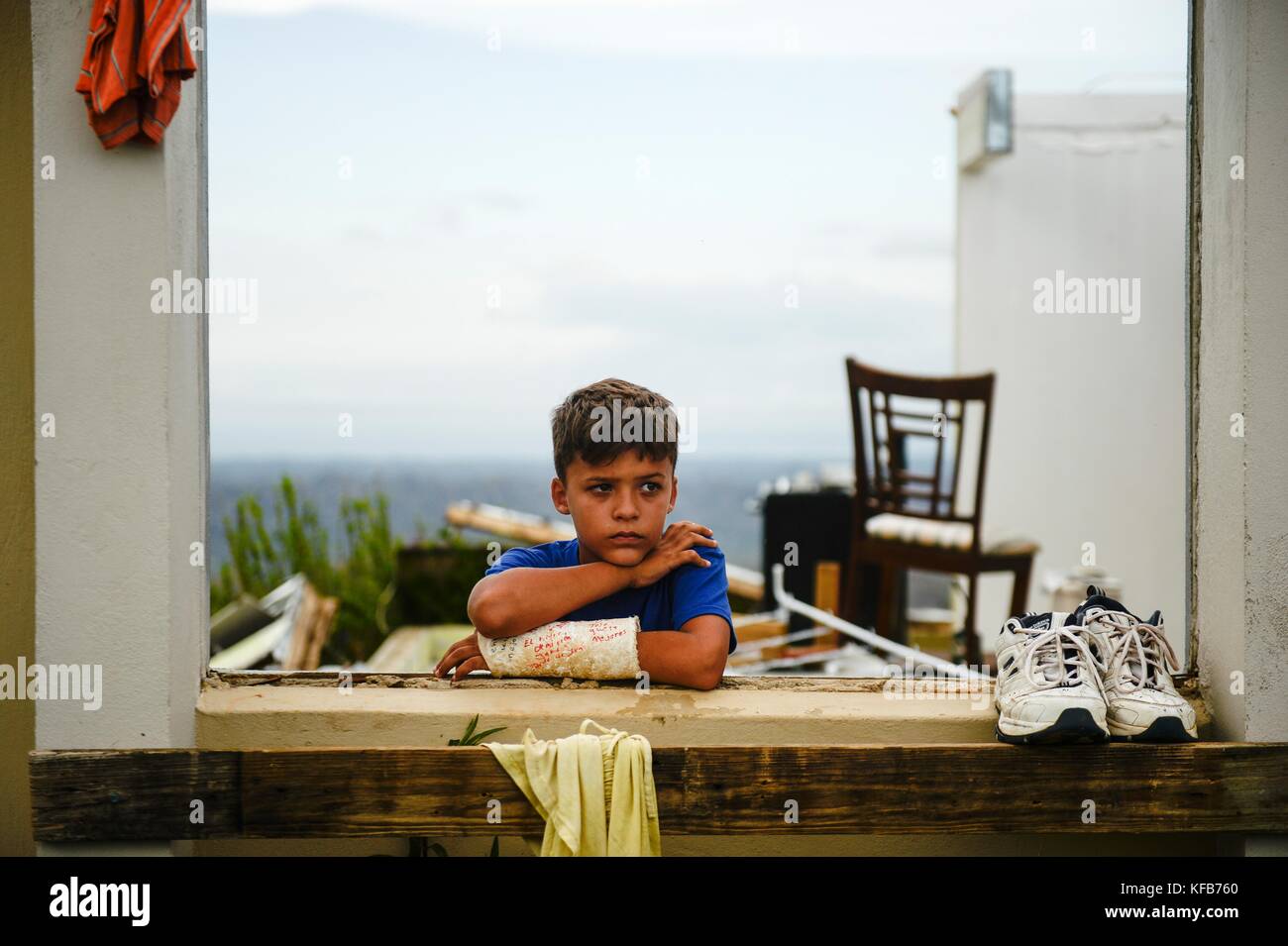 A child stands in the window of a destroyed home in the aftermath of Hurricane Maria October 12, 2017 in Utuado, Puerto Rico.   (photo by Joshua L. DeMotts via Planetpix) Stock Photo
