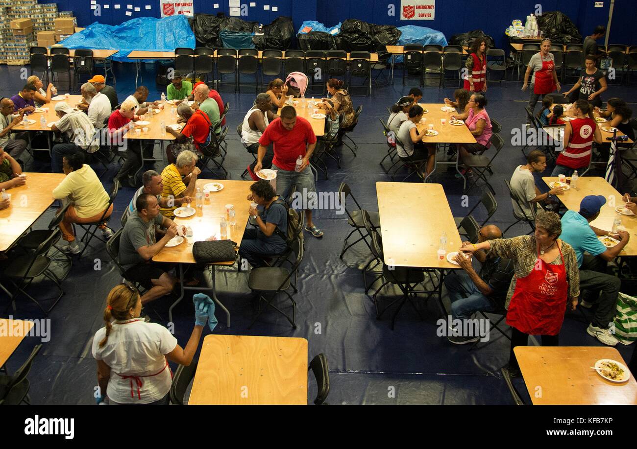 Puerto Rican residents eat a meal at the El Comedor del Salvation Army de San Juan shelter during relief efforts in the aftermath of Hurricane Maria October 18, 2017 in San Juan, Puerto Rico.   (photo by Yuisa Rios via Planetpix) Stock Photo