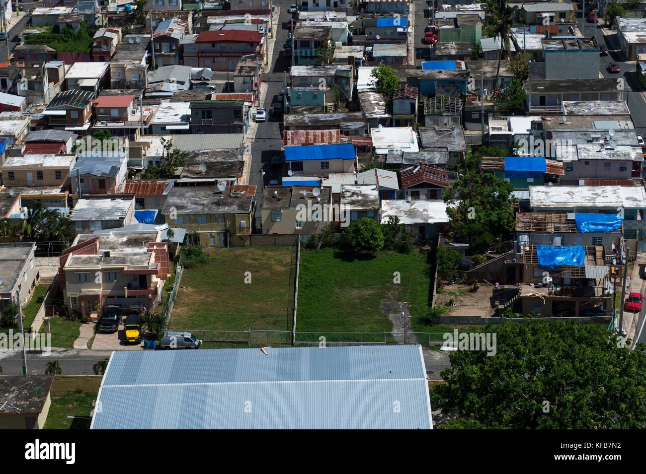 Aerial view of blue, plastic tarps over damaged roofs in the aftermath