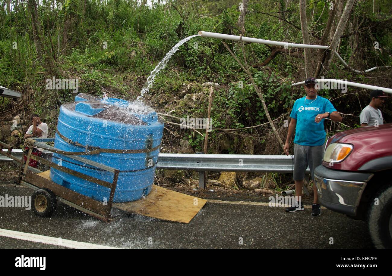 Puerto Rican residents collect stream water in tanks during relief efforts in the aftermath of Hurricane Maria October 15, 2017 in Utuado, Puerto Rico.   (photo by Yuisa Rios via Planetpix) Stock Photo