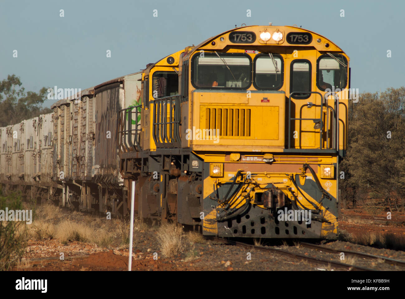 A locomotive hauling rail freight through outback country, Australia Stock Photo
