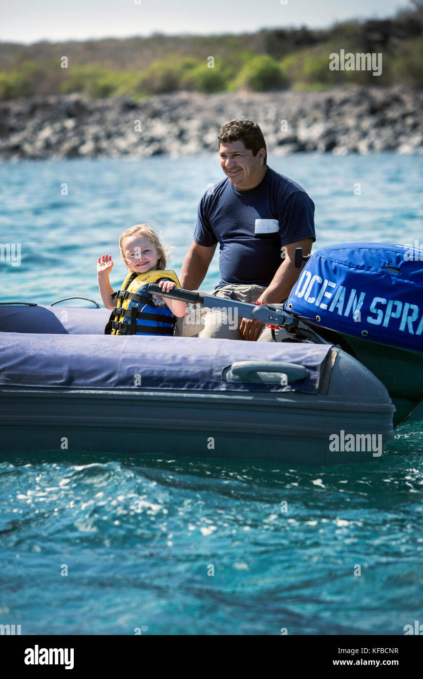 GALAPAGOS ISLANDS, ECUADOR, a young girl driving the dingy boat in the water near Punta Suarez on Espanola Island Stock Photo