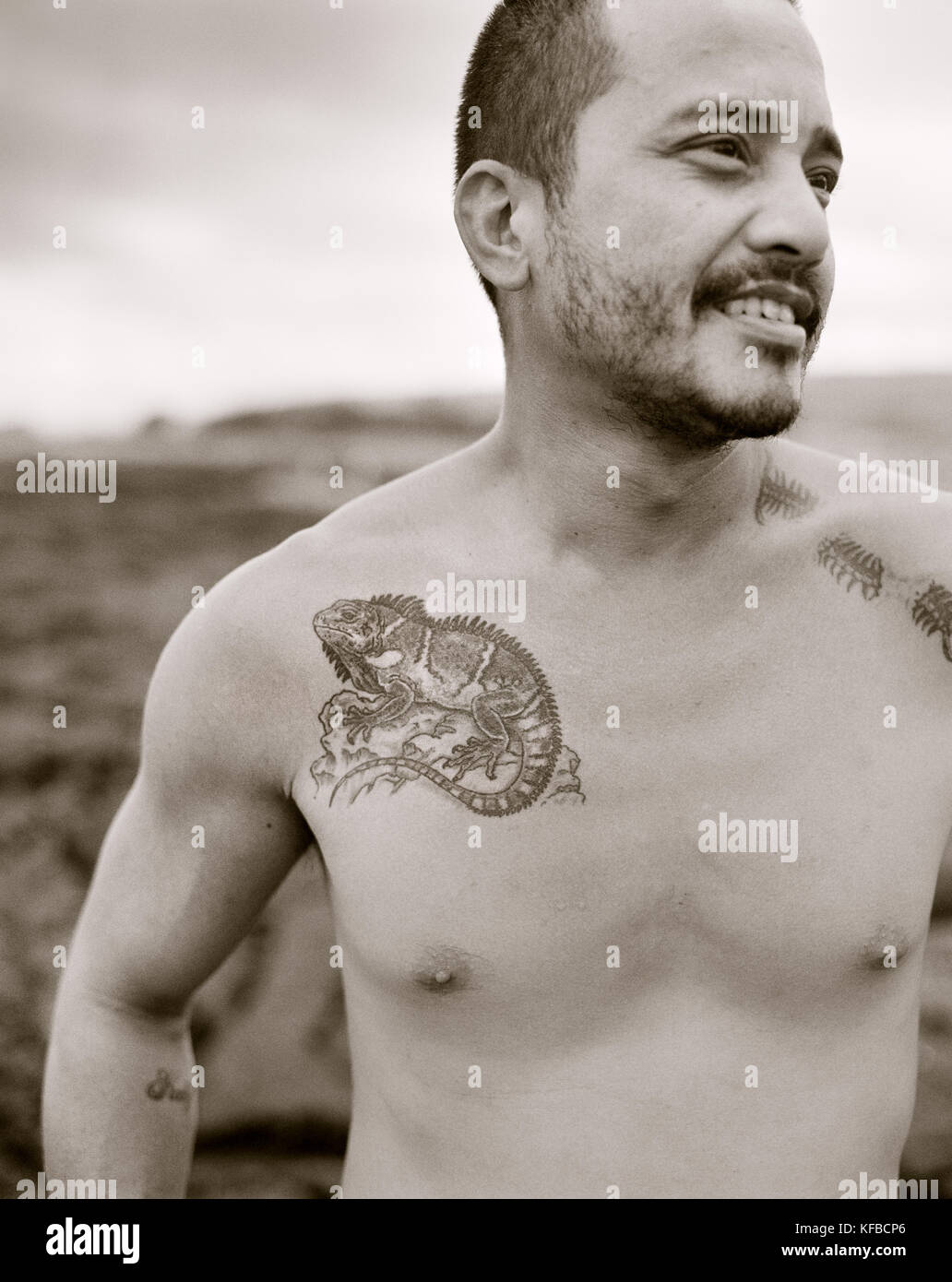USA, Hawaii, The Big Island, smiling fisherman with a tattoo on chest at Puna Lu'u Beach (B&W) Stock Photo